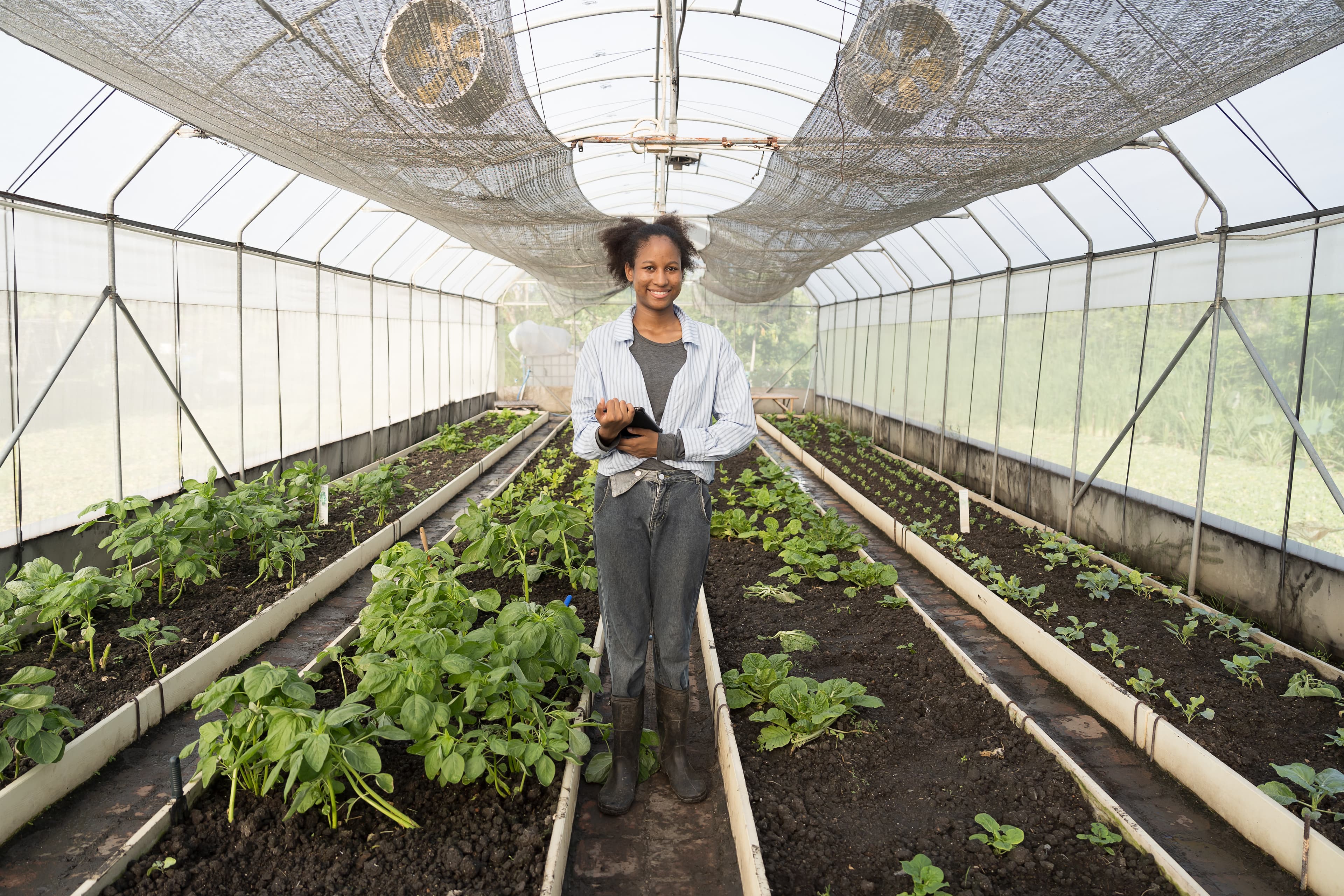 Student learning about herbs in a greenhouse setting